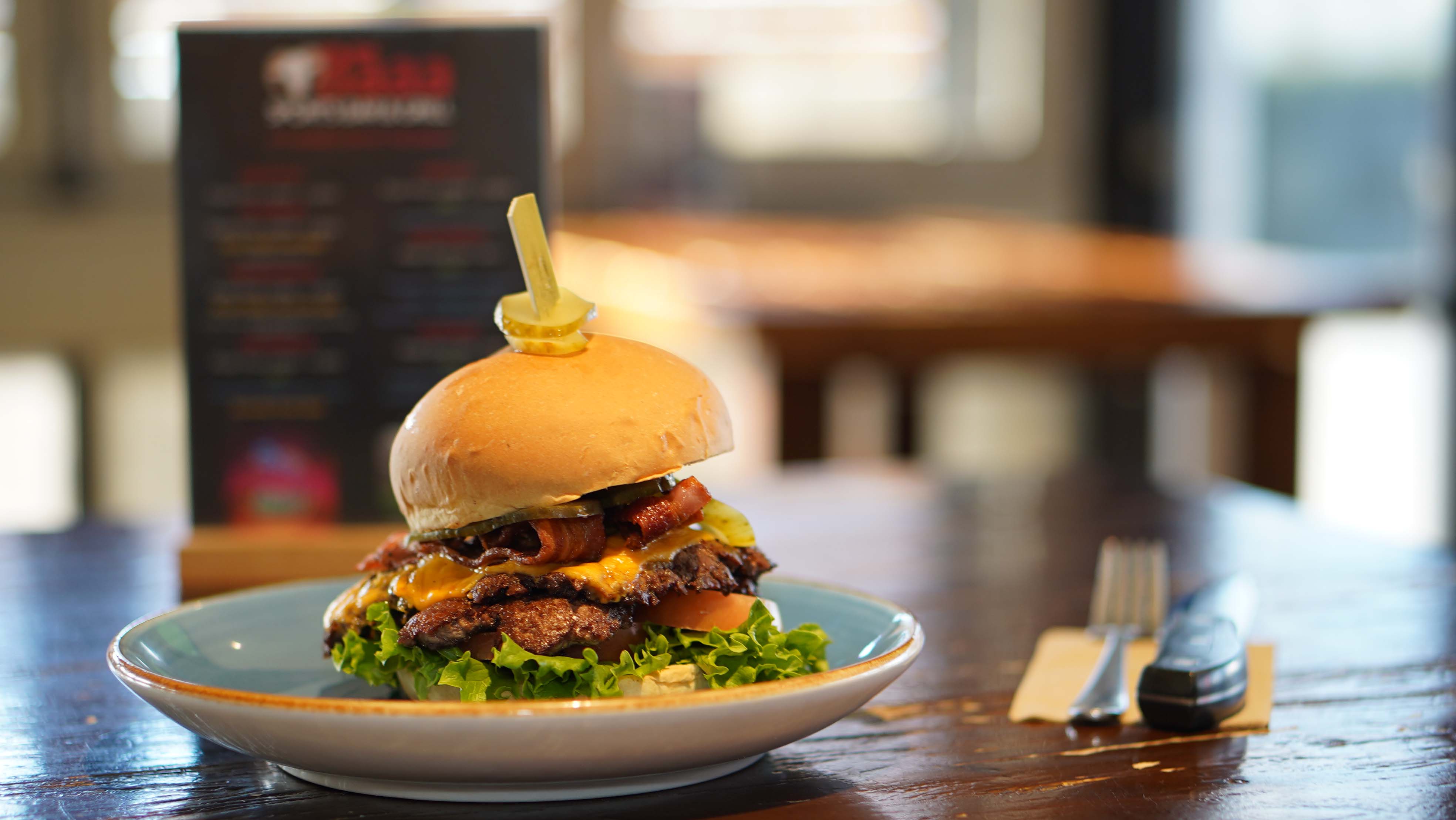 A stacked burger served on a blue plate